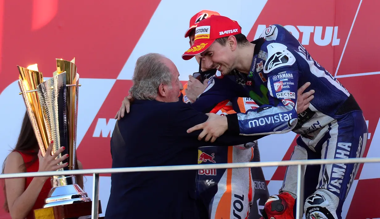 Jorge Lorenzo mendapat ucapan selamat dari Raja Spanyol Juan Carlos di atas podium MotoGP Valencia di Sirkuit Ricardo Tormo, Valencia, Spanyol, Minggu (8/11/2015). (AFP Photo/Jose Jordan)