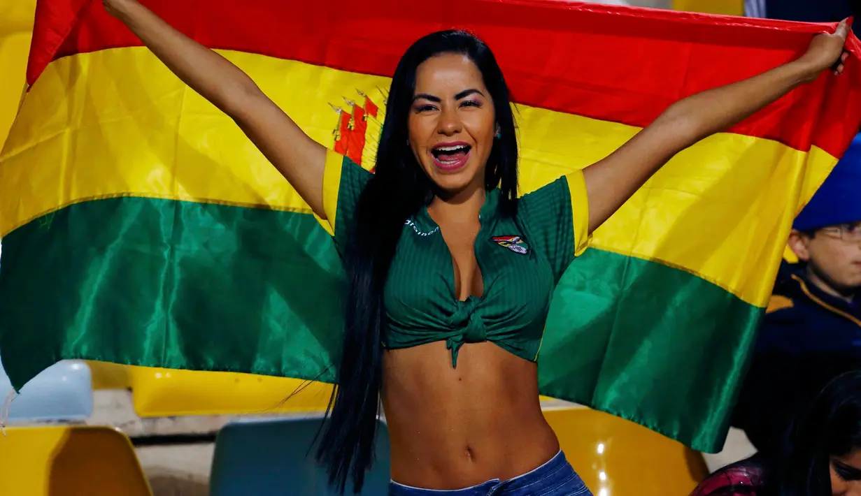 Suporter cantik dan seksi Bolivia bersorak membentangkan bendera negaranya saat menyaksikan laga Timnas Bolivia vs Meksiko di Copa America 2015 di Estadio Sausalito di Vina del Mar, Chile (12/6/2015). (REUTERS/Ivan Alvarado)