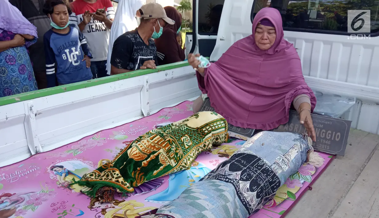 Warga memindahkan dua jasad dari kuburan di Desa Toto Selatan, Kabupaten Bone Bolango, Gorontalo, Sabtu (12/1). Kepala Desa Toto Selatan Taufik Baladraf mengaku sudah memediasi keluarga yang saling bersengketa. (Liputan6.com/Arfandi Ibrahim)