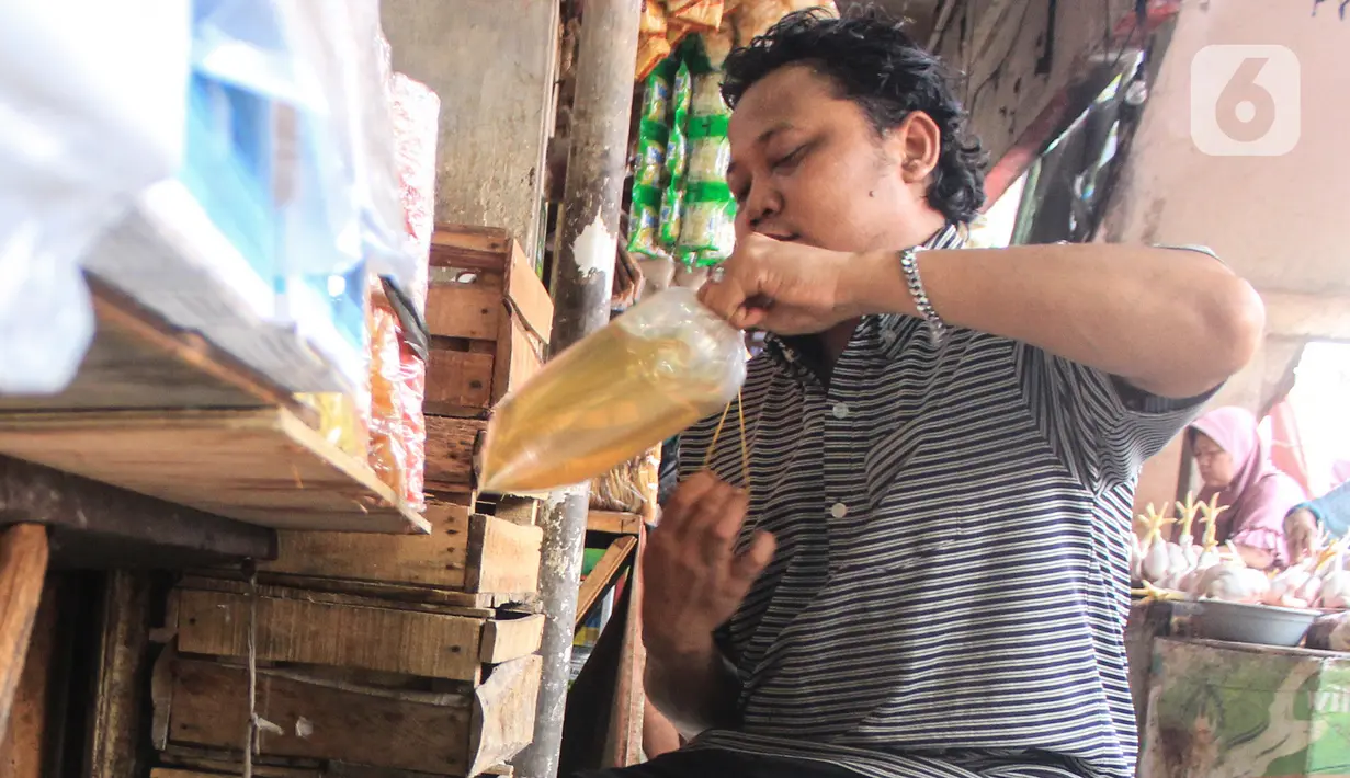 Pedagang memasukkan minyak goreng curah ke dalam kantong plastik di Pasar Kebayoran, Jakarta, Selasa (31/5/2022). Kementerian Perindustrian mencabut subsidi minyak goreng curah kepada pelaku usaha mulai Selasa (31/5/2022). (Liputan6.com/Johan Tallo)