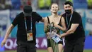 Tampaknya mungkin ada motif terselubung masuknya Pitch Invader cantik itu. Namun terlepas dari itu semua, aksi penyusup cantik seperti ini kadang menjadi bumbu pemanis pertandingan. Laga dilanjutkan dan Belgia keluar sebagai pemenang dengan skor 0-2. (Foto: AP/Pool/Anatoly Maltsev)