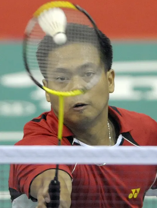 File foto pada 11 Desember 2009 menunjukkan Markis Kido dari Indonesia melakukan pukulan balasan saat melawan Chanda Vanvilay dan Yothin Latsavong dari Laos di perempat final beregu putra SEAGAMES ke-25 di Vientiane. Kido meninggal dunia pada Senin, 14 Juni 2021 di usia 36 tahun. (LIU JIN/AFP)