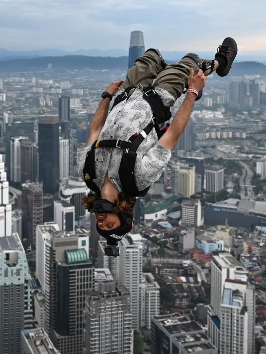 Penerjun Australia Jon McGregor melompat dari dek terbuka Menara Kuala Lumpur saat International Tower Jump, Kuala Lumpur, Malaysia, 3 Februari 2023. Lebih dari 100 penerjun melompat dari Menara Kuala Lumpur setinggi 300 meter yang terkenal tersebut. (MOHD RASFAN/AFP)