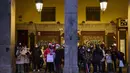 Orang-orang yang memakai masker untuk melindungi diri dari penyebaran virus corona, menunggu hujan berhenti di pusat kota Madrid, Spanyol (8/12/2021). PM Spanyol mendesak warga untuk "tetap berhati-hati" tentang COVID-19 selama liburan perayaan Natal. (AP Photo/Manu Fernandez)