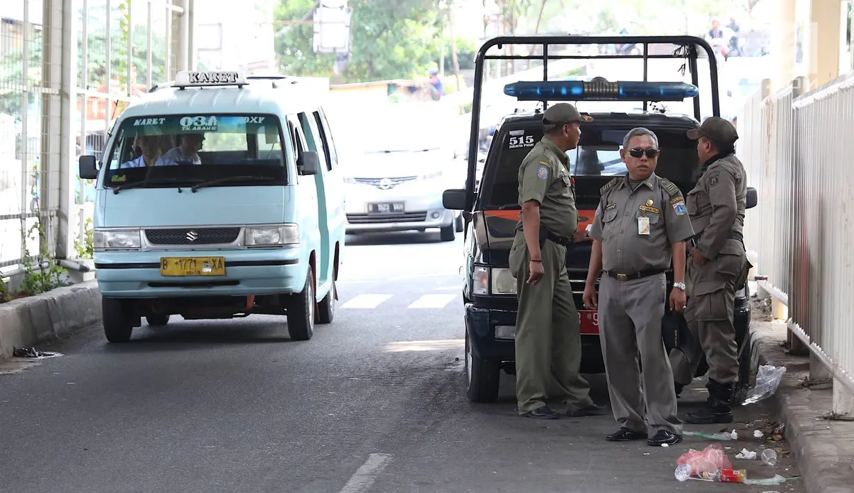 Personel Satpol PP berjaga di bawah skybridge Tanah Abang, Jakarta, Selasa (8/1). Penjagaan tersebut dilakukan untuk mencegah PKL yang berjualan di sekitar Stasiun Tanah Abang. (Liputan6.com/Immanuel Antonius)