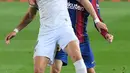 Pemain Barcelona Clement Lenglet (belakang) memperebutkan bola dengan pemain Huesca Rafa Mir pada pertandingan Liga Spanyol di Stadion Camp Nou, Barcelona, Spanyol, Senin (15/3/2021). Barcelona menang 4-1. (LLUIS GENE/AFP)
