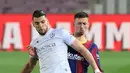 Pemain Barcelona Clement Lenglet (belakang) memperebutkan bola dengan pemain Huesca Rafa Mir pada pertandingan Liga Spanyol di Stadion Camp Nou, Barcelona, Spanyol, Senin (15/3/2021). Barcelona menang 4-1. (LLUIS GENE/AFP)