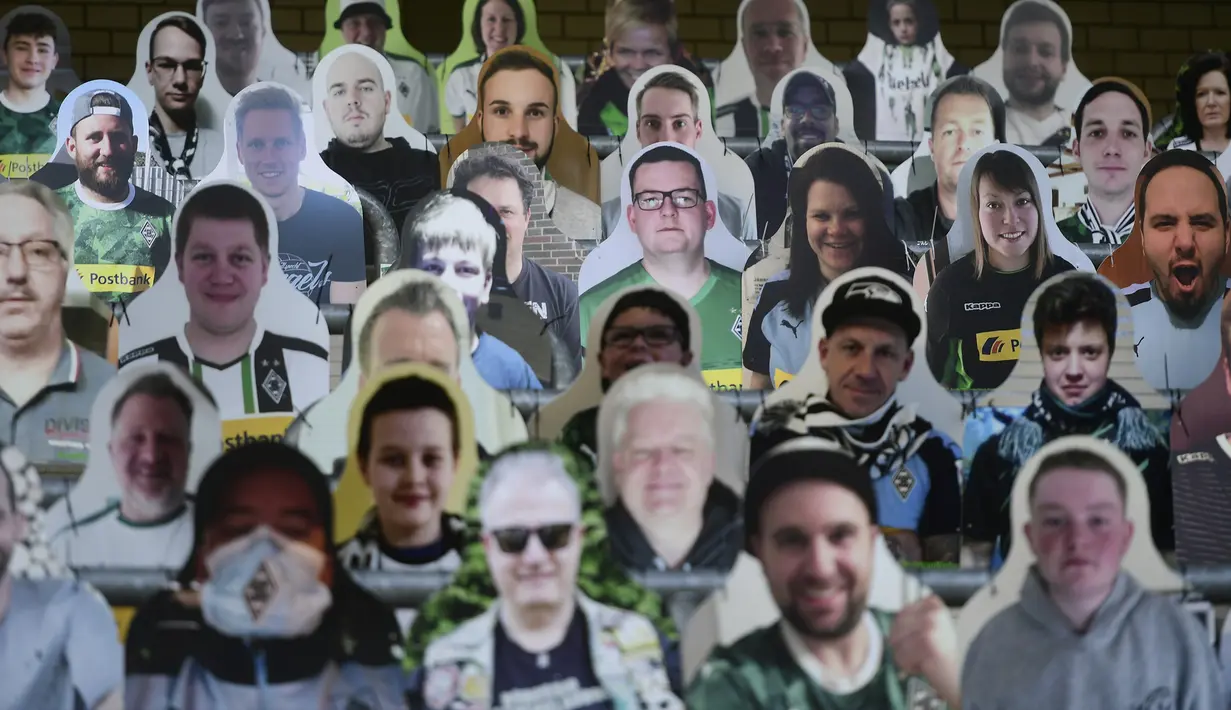 Cardboard pendukung Borussia Moenchegladbach mengisi kursi penonton di stadion Borussia Park, Moenchengladbach, Jerman, Rabu (20/5/2020). Ribuan Cardboard gambar suporter Borussia Moenchegladbach dipasang untuk mendukung timnya saat berlaga di kompetisi Bundesliga. (AFP/Ina Fassbender)