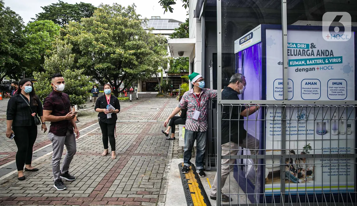 Para jemaat masuk ke bilik disinfektan sebelum mengikuti ibadah di Gereja Katedral, Jakarta, Kamis (24/12/2020). Kapasitas gereja untuk ibadat misa Natal sebanyak 309 kursi, yaitu 20 persen dari kapasitas Gereja Katedral. (Liputan6.com/Faizal Fanani)