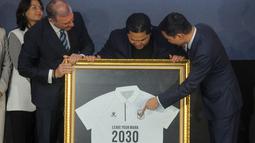 Ketua Umum PSSI, Erick Thohir (tengah) mendapatkan cendera mata kaos polo dari Chairman of CEO Kelme Global Clinten KE (kanan) dan Vice Chairman of Kelme Global, Borja Garcia Nieto (kiri) dalam acara perkenalan kerja sama yang berlangsung di Hotel Tribrata, Jakarta, Jumat (23/01/2026). (Bola.com/Bagaskara Lazuardi)