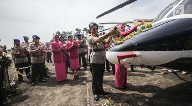 Kapolri Jenderal Tito Karnavian  dan Istri Tri Suswati menyiramkan kembang saat menyerahkan dua helikopter jenis Bell 429 IGW dari PT Multi Pasific California usai menghadiri  HUT Korpolairud ke-67, Tangerang, Selasa (5/11). (Liputan6.com/Faizal Fanani)