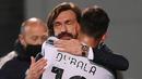 Manajer tim Juventus, Andrea Pirlo memeluk striker Paulo Dybala usai ditarik keluar dalam laga lanjutan Liga Italia 2020/2021 pekan ke-36 di Mapei-Citta del Tricolore Stadium, Rabu (12/5/2021). Juventus menang 3-1 atas Sassuolo. (AFP/Marco Bertorello)