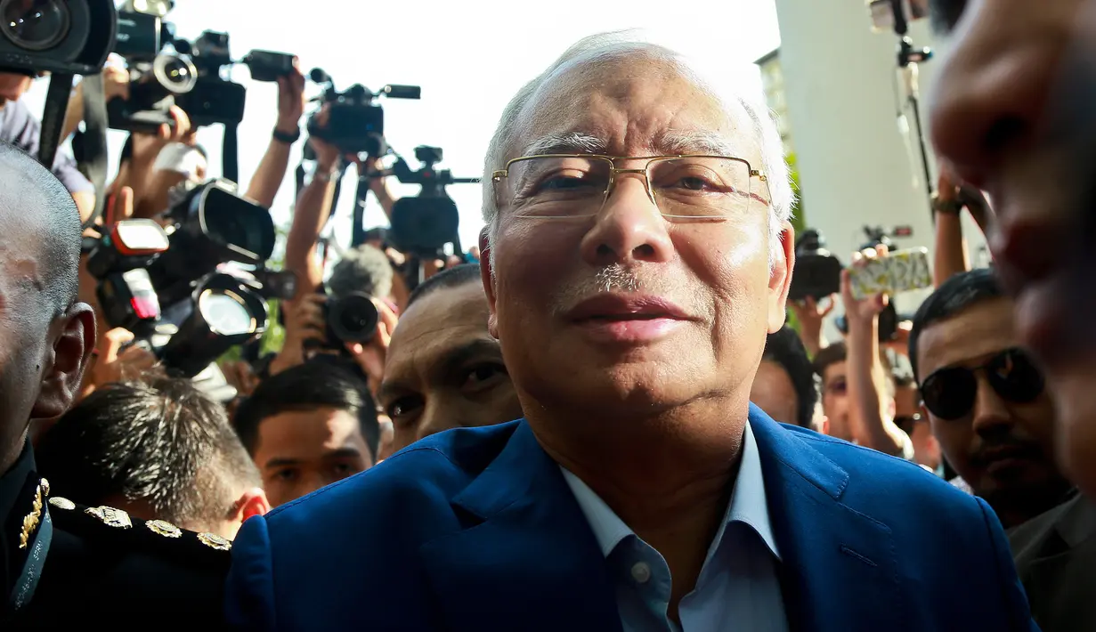 Mantan Perdana Menteri Najib Razak memasuki gedung kantor Komisi Anti-Korupsi Malaysia (MACC) untuk menjalani pemeriksaan di Putrajaya, Selasa (22/5). Kedatangan Najib ini memenuhi surat panggilan yang diantarkan ke rumahnya, pekan lalu. (AP/Sadiq Asyraf)
