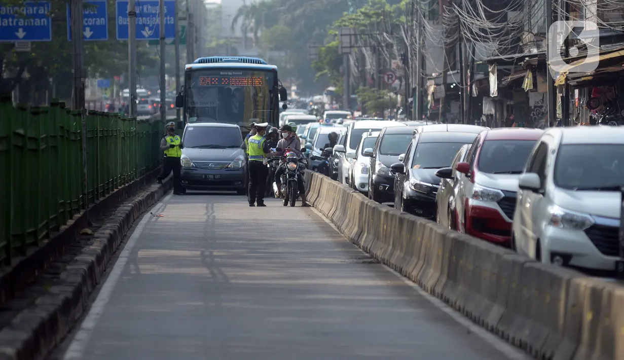 Polisi menindak pengendara sepeda motor yang melanggar aturan lalu lintas di Jalan Pasar Rumput, Manggarai, Jakarta, Selasa (21/7/2020). Polisi akan menggelar Operasi Patuh Jaya 2020 pada 23 Juli sampai 5 Agustus 2020 di seluruh Polda se-Indonesia. (merdeka.com/Imam Buhori)