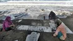Warga mengambil sisa keramik dari sebuah bangunan permanen yang hancur akibat terjangan ombak pasang di Karanghawu, Pelabuhan Ratu, Sukabumi (29/7). Gelombang pasang selama beberapa hari ini menyebabkan puluhan bangunan hancur. (Merdeka.com/Arie Basuki)