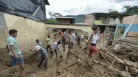 Keluarga dan tim penyelamat mencari korban banjir dan tanah longsor di Mocoa, Kolombia, Minggu (2/4). Sekitar 1.100 tentara dan polisi dikerahkan dalam upaya penyelamatan akibat bencana yang terjadi Sabtu dini hari kemarin. (LUIS ROBAYO/AFP)
