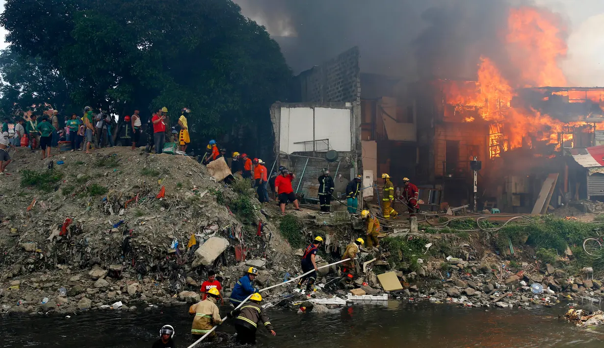 Kebakaran melanda kawasan kumuh di Manila, Filipina (11/8). Sejauh ini kebakaran menghancurkan 300 rumah dan mengakibatkan 800 keluarga harus dievakuasi. (AP Photo/Bullit Marquez)
