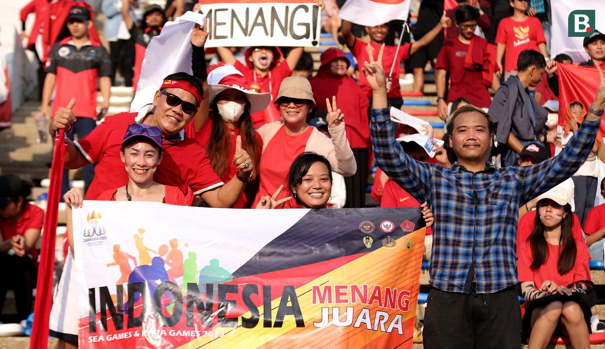 Pendukung Indonesia membentangkan spanduk bertuliskan "Indonesia Menang Juara SEA Games & Paragames 2023" saat laga kedua Grup A Sepak Bola SEA Games 2023 antara Timnas Indonesia melawan Timnas Myanmar di Olympic Stadium, Phnom Penh, Kamboja, Kamis (04/05/2023). Skuad asuhan Indra Sjafri tersebut berhasil menang dengan skor telak 5-0. (Bola.com/Abdul Aziz)