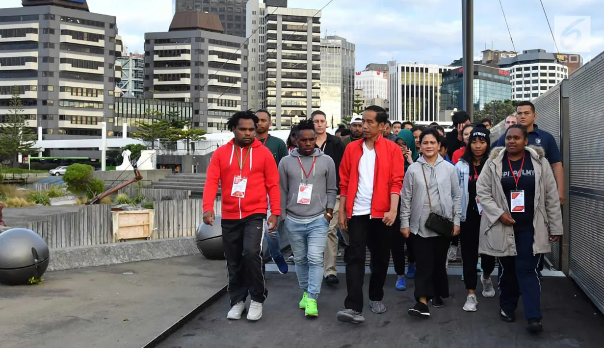 Presiden Joko Widodo dan Ibu Negara Iriana Joko Widodo berjalan kaki bersama pelajar dan mahasiswa Indonesia di sekitar Water Front di Selandia Baru (19/3). Jokowi tampil mengenakan kaos putih dan jaket merah. (Liputan6.com/Pool/Biro Pers Setpres)