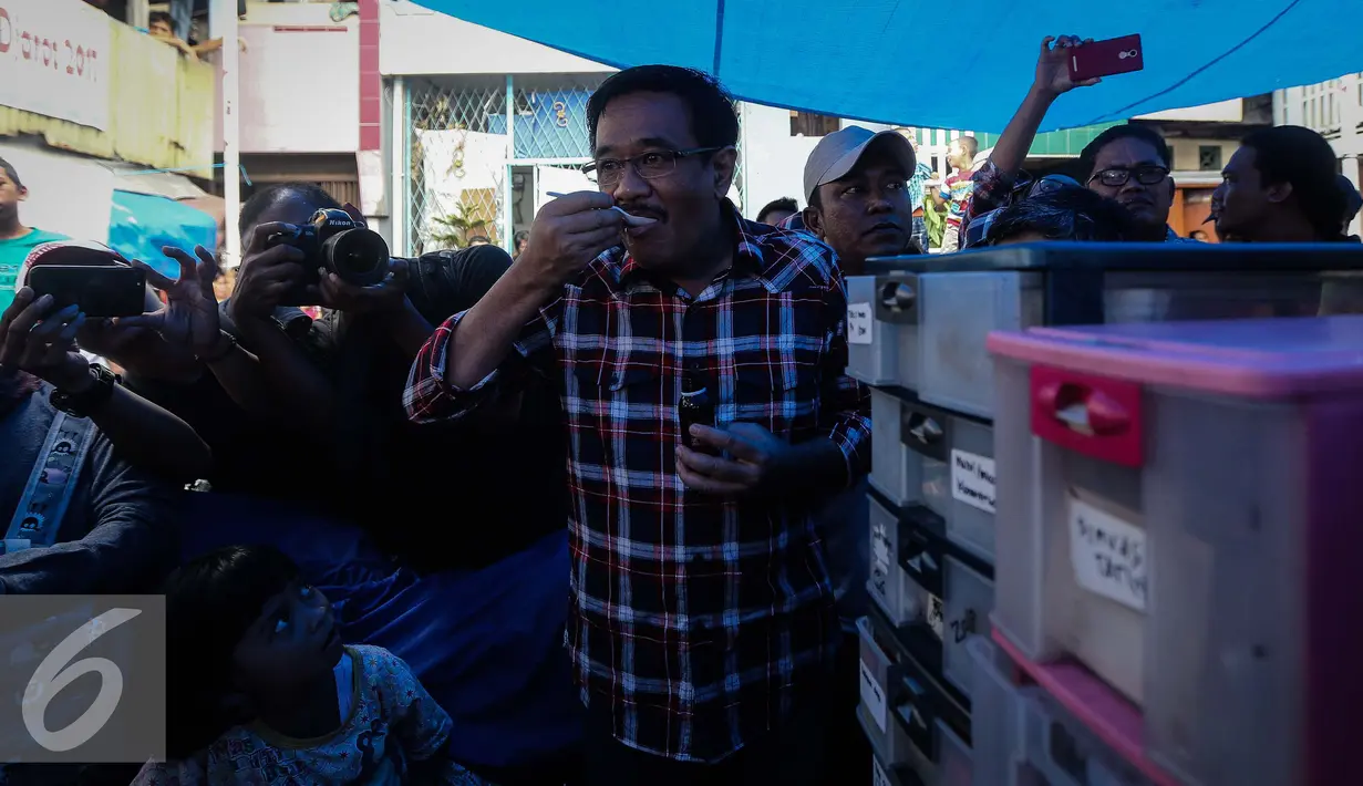 Djarot Saiful Hidayat meminum obat saat memberikan pengobatan gratis kepada warga RW 07, Jembatan Besi, Jakarta (15/1). Pengobatan gratis ini dilakukan untuk membantu warga tidak mampu di sekitar Jakarta. (Liputan6.com/Faizal Fanani)