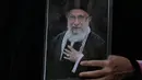 Seorang wanita memegang poster mendiang Pemimpin Tertinggi Iran Ayatollah Ali Khamenei selama prosesi pemakamannya di Teheran, Iran, Senin, 6 Juli 2026. (AP Photo/Vahid Salemi)