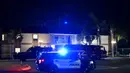 Petugas polisi berdiri di luar gedung perkantoran, beberapa orang tewas dalam penembakan di Orange, California (31/3/2021).  Pihak berwenang mengatakan bahwa empat orang, termasuk seorang anak, tewas dalam penembakan dan dua lainnya telah diangkut ke rumah sakit setempat. (AFP/Patrick T. Fallon)