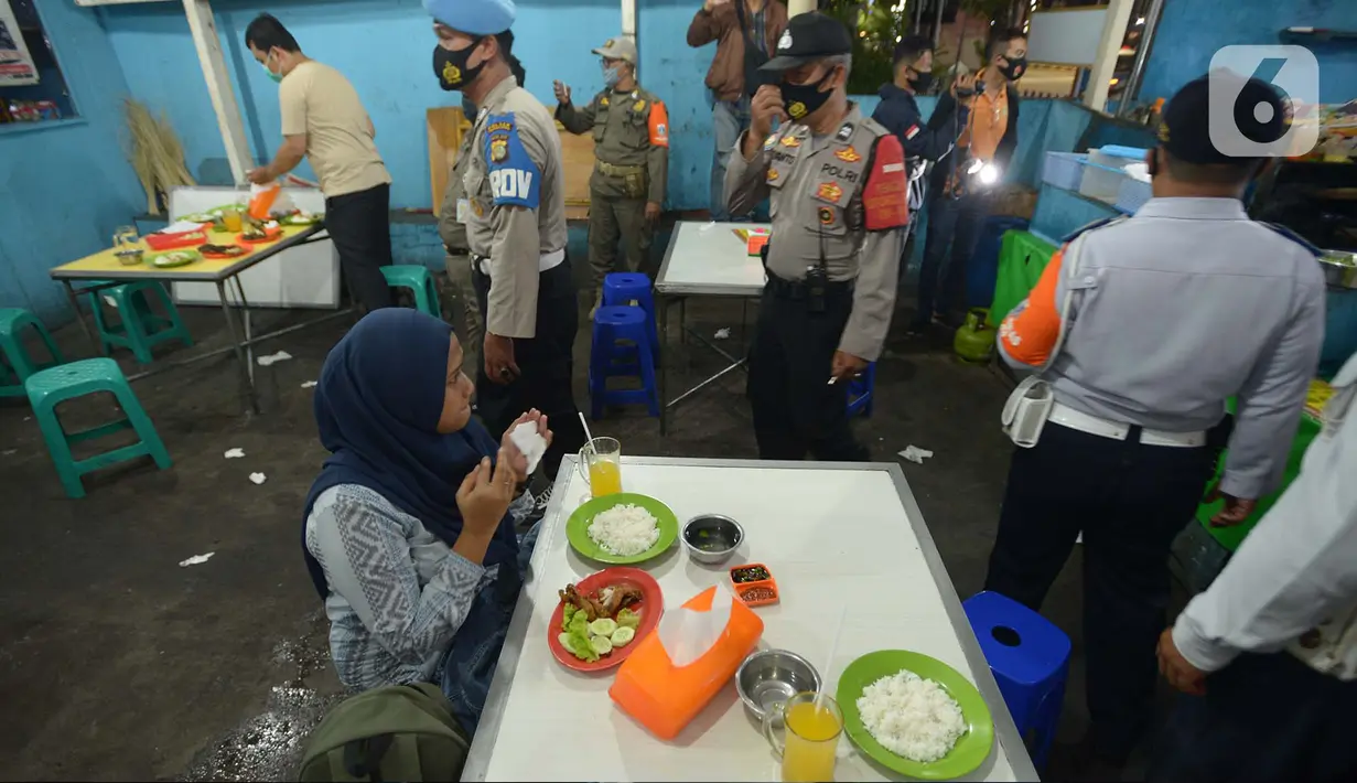 Petugas Gabungan melakukan penertiban penerapan PSBB tempat makan yang masih menyediakan tempat konsumen di wilayah Kecamatan Pulogadung, Jakarta, Jumat (18/9/2020). Malam, Razia dilakukan memastikan ketidakadaannya konsumen makan ditempat tersebut. (merdeka.com/Imam Buhori)