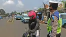 Polisi lalu lintas melaksanakan pengawasan dalam penerapan Pembatasan Sosial Bersekala Besar (PSBB) di jalan perbatasan Depok-Jakarta, Jumat (10/4/2020). Petugas menyetop kendaraan untuk menghimbau kewajiban memakai masker dan aturan penumpang dalam satu kendaraan.  (Liputan6.com/Herman Zakharia)