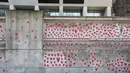 Gambar hati dilukis oleh seorang anggota keluarga yang berduka di Tembok Peringatan COVID-19, di seberang Gedung Parlemen, di London, Senin (29/3/2021). Mural hampir 150.000 lukisan hati itu untuk mengenang ribuan orang yang meninggal akibat virus corona di Inggris. (Lucianna Guerra/PA melalui AP)