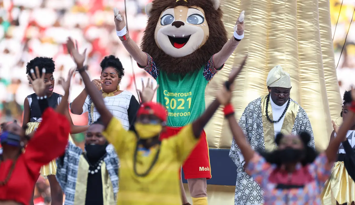 Maskot Piala Afrika (CAN), Mola (tengah) bersama para penari saat upacara pembukaan turnamen sepak bola Piala Afrika (CAN) 2021 di Stade d'Olembé di Yaounde (9/1/2022). Piala Afrika 2021 seharusnya digelar Januari 2021 tapi kemudian diundur karena pandemi. (AFP/Kenzo Tribouillard)