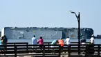 Warga melihat kapal kargo Golden Ray yang terbalik di lepas pantai negara bagian Georgia, Amerika Serikat, Minggu (8/9/2019). Kapal kargo Korea Selatan yang mengangkut 4.000 mobil itu terbalik saat menuju Timur Tengah. (Bobby Haven/The Brunswick News via AP)