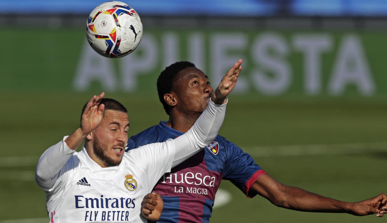 Penyerang Real Madrid, Eden Hazard, berebut bola dengan gelandang Huesca, Kelechi Nwakali, pada laga lanjutan Liga Spanyol di Stadion Alfredo Di Stefano, Sabtu (31/10/2020) malam WIB. Real Madrid menang 4-1 atas Huesca. (AP Photo/Manu Fernandez)