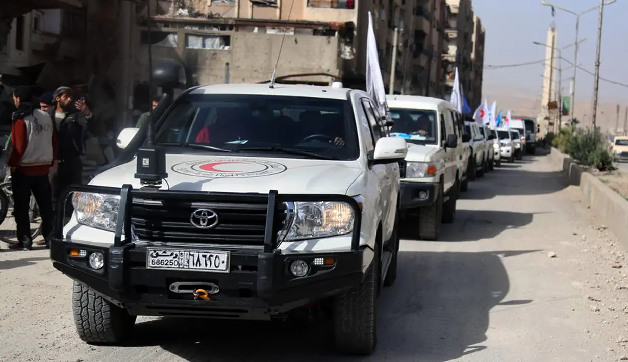Konvoi truk bantuan Bulan Sabit Merah Suriah tiba di Douma, Ghouta Timur, Damaskus, Suriah, Senin (5/3). Dari 46 truk bantuan, 10 kendaraan gagal melakukan distribusi karena terganggu oleh bombardir udara dan artileri. (Syrian Red Crescent via AP)