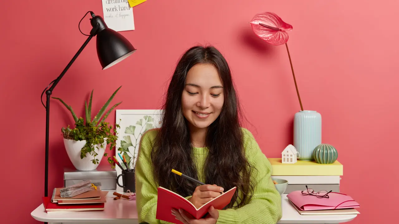 Seorang perempuan sedang mencatat di buku catatannya (Foto Dok: Freepik/freepik)