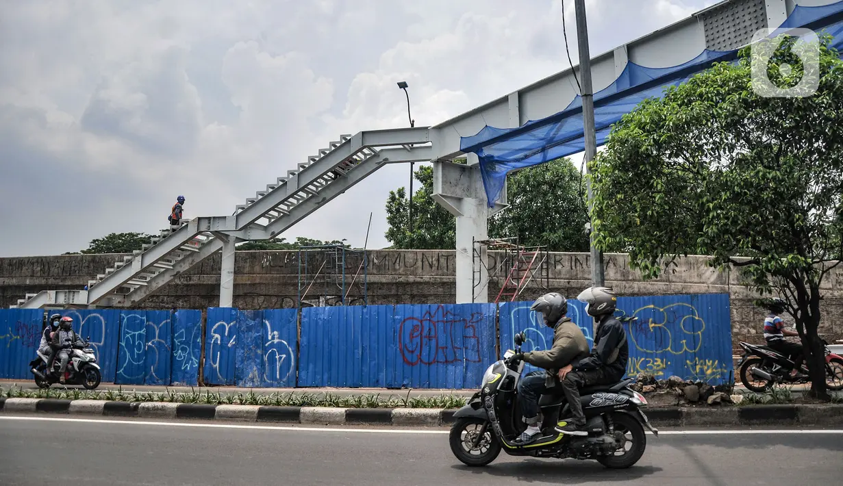 Kendaraan melintas sekitar pembangunan JPO di Jalan Kolonel Sugiono, Duren Sawit, Jakarta Timur, Rabu (3/11/2021). Pembangunan JPO tersebut bertujuan memberikan kenyamanan serta keselamatan bagi pejalan kaki dan mencegah kecelakaan. (merdeka.com/Iqbal S. Nugroho)