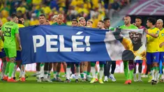Para pemain Brasil membentangkan spanduk dukungan untuk Pele yang sedang sakit pada akhir pertandingan sepak bola babak 16 besar Piala Dunia 2022 antara Brasil dan Korea Selatan di Stadium 974, Doha, Qatar, 5 Desember 2022. (AP Photo/Jin-Man Lee)