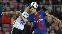 Pemain Valencia, Rodri berebut bola dengan gelandang Barcelona, Sergio Busquets pada semifinal pertama Copa del Rey di Stadion Camp Nou, Jumat (2/2). Barcelona menang 1-0 berkat gol semata wayang Luis Suarez. (AFP PHOTO/LLUIS GENE)