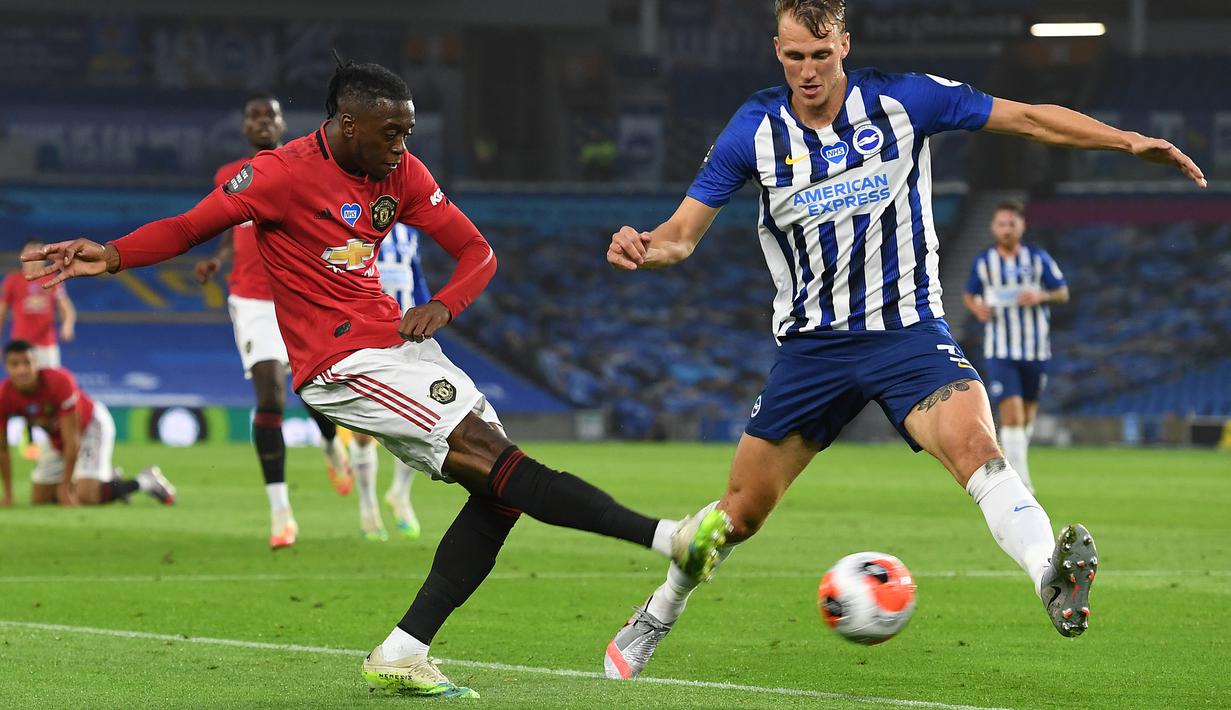 Bek Manchester United, Aaron Wan-Bissaka, berebut bola dengan pemain Brighton pada laga Premier League pekan ke-32 di Stadion Falmer, Rabu (1/7/2020) dini hari WIB. Manchester United menang 3-0 atas Brighton. (AFP/Andy Rain/pool)
