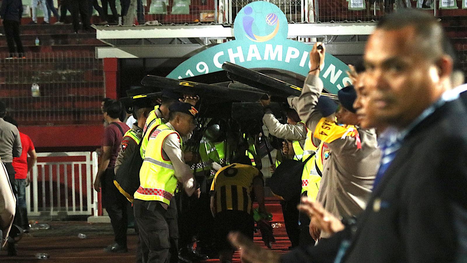 Pemain Timnas Malaysia U-19 mendapat perlindungan aparat keamanan saat menuju ruang ganti Stadion Gelora Delta, Sidoarjo, seusai semifinal kontra Indonesia di semifinal Piala AFF U-19 2018 (12/7/2018). (Bola.com/Aditya Wany)