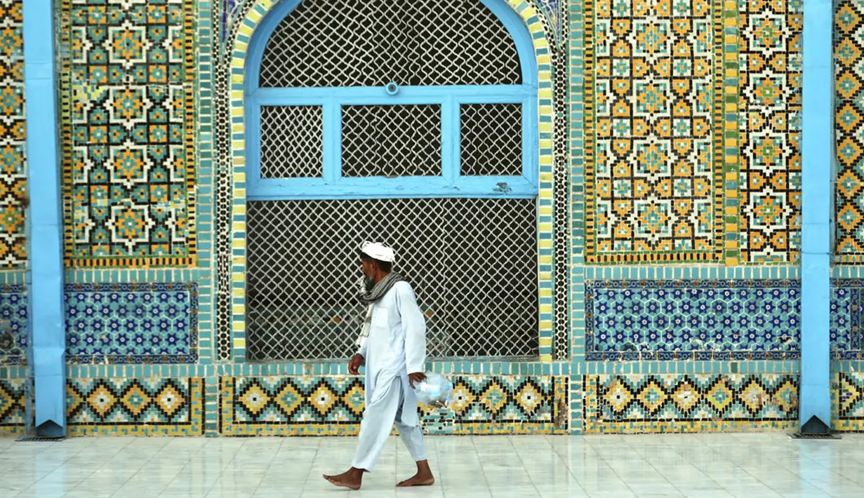 Seorang pria mengunjungi mengunjungi Hazrat-e-Ali atau Masjid Biru di Mazar-e-Sharif, Afghanistan, Rabu (7/7/2021). Menurut Atlas Obscura, struktur Masjid Biru tampak mengesankan karena arsitektur yang menggunakan ubin tanah liat. (AP Photo/Rahmat Gul)