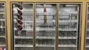 Rak susu sebagian besar kosong di toko kelontong Giant, Washington, Selasa (11/1/2022). Varian Omicron yang sangat menular membuat pekerja sakit, menciptakan kekurangan tenaga kerja yang memengaruhi pengiriman produk dan pengisian kembali rak-rak toko di seluruh negeri. (AP Photo/Parker Purifoy)