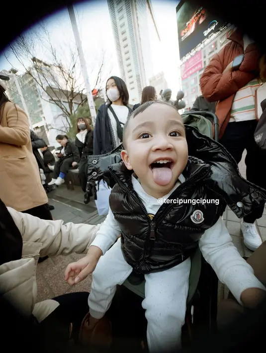 Ia duduk di stroller dengan busana hitam putih. Cipung mengenakan setelan sweater putih dan puffy vest hitam. [@tercipungcipung]