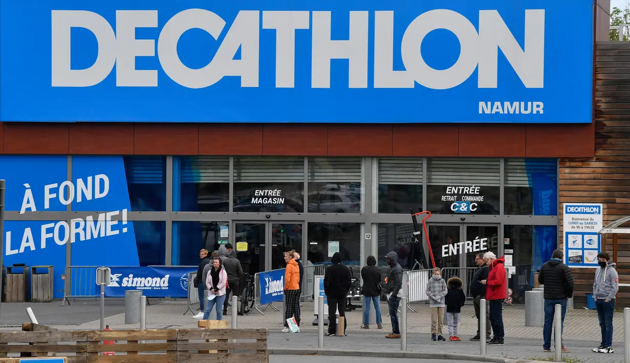 Orang-orang menjaga jarak aman ketika antre di luar toko olahraga Decathlon setelah pelonggaran lockdown secara bertahap di Namur, Senin (11/5/2020). Warga Belgia rela mengantre selama beberapa jam sebelum toko dibuka untuk berbelanja pertama kalinya sejak lockdown pada Maret lalu. (JOHN THYS/AFP)