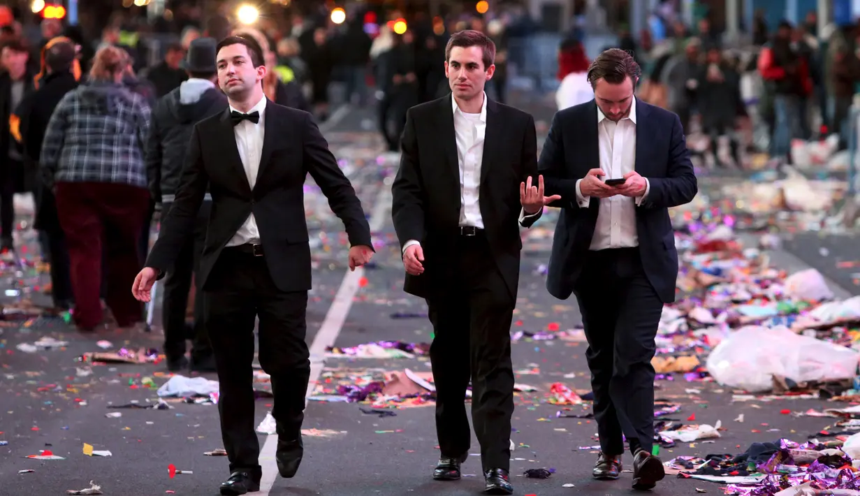 Sejumlah warga berjalan disamping tumpukan sampah usai perayaan tahun baru 2016 di Times Square di Manhattan borough, New York, USA (1/1/2016). (REUTERS/Andrew Kelly)