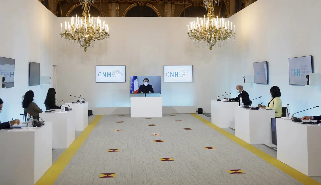 Presiden Prancis Emmanuel Macron terlihat di layar saat dia menghadiri konferensi  Kemanusiaan Nasional (NHC), di Kementerian Luar Negeri di Paris, Kamis (17/12/2020).  Presiden Macron akan lanjut kerja di kediamannya setelah positif Covid-19. (Charles Platiau/Pool via AP)