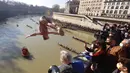 Marco Fois dari Italia melompat ke Sungai Tiber dari Jembatan Cavour setinggi 18 meter (59 kaki) untuk merayakan Tahun Baru di Roma, 1 Januari 2022. (AP Photo/Riccardo De Luca)