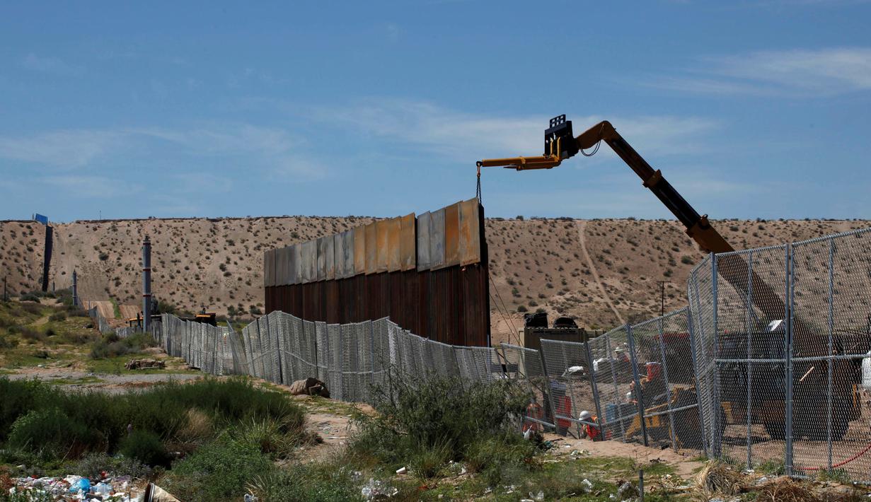 Alat berat memasang pagar pembatas yang merupakan bagian dari dinding perbatasan AS-Meksiko di Sunland Park, AS (09/9). Capres AS, Donald Trump berjanji akan membangun tembok yang kuat untuk menggantikan sekat pembatas. (REUTERS/Jose Luis Gonzalez)