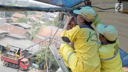 Petugas memerbaiki atap JPO di sekitar kawasan Lenteng Agung, Jakarta, Selasa (28/8). Hal itu dilakukan guna memberikan kenyamanan bagi pengguna JPO, mengingat banyak bagian dari JPO tersebut yang telah keropos dan rusak. (Liputan6.com/Immanuel Antonius)