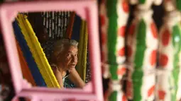 Maria Ponce (86) terlihat di cermin yang menghiasi rumahnya yang terbuat dari botol plastik bekas di Desa El Borbollon, El Transito, San Salvador, El Salvador 14 Maret 2017. (AFP Photo/Marvin Recinos)