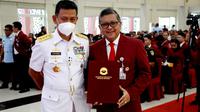 Rektor Unhan RI Laksamana Madya TNI Prof. Amarulla Octavian memberikan piagam penghargaan kepada Sekjen PDIP Hasto Kristiyanto berupa map berwarna merah. (Liputan6.com/Putu Merta Surya Putra)